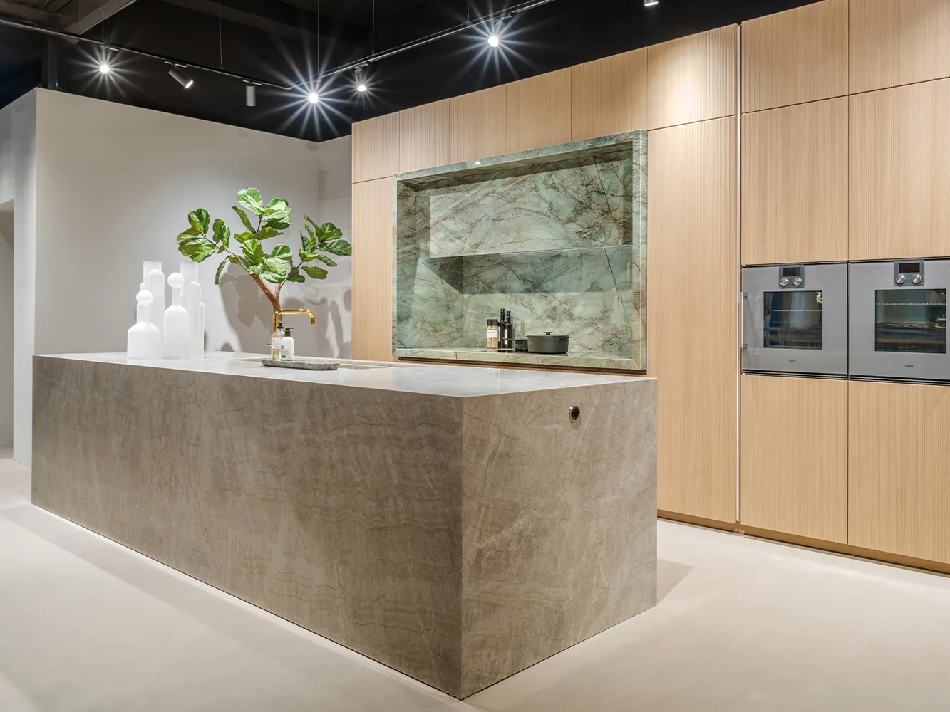 Cuisine design sans poignées i-luminate avec îlot central en quartzite et façades de cuisine en chêne clair.