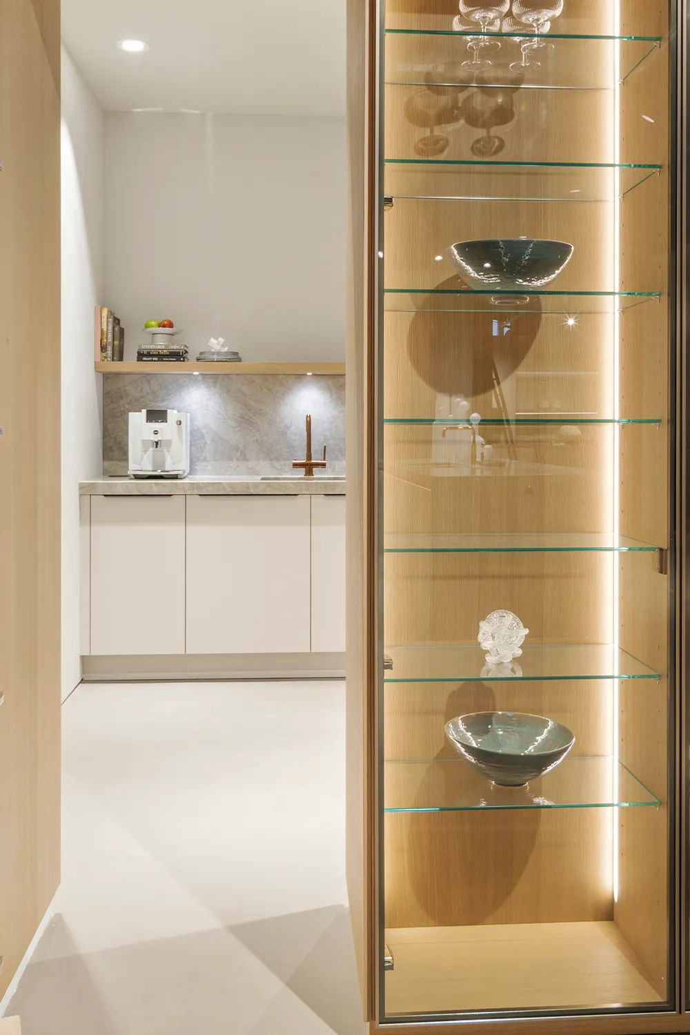 i-luminate designkeuken met messing vitrines en een verborgen bijkeuken voor opslag.