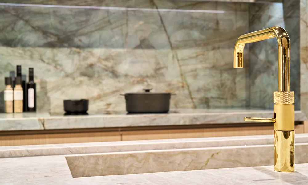 i-luminate designer kitchen with premium equipment and golden faucet.